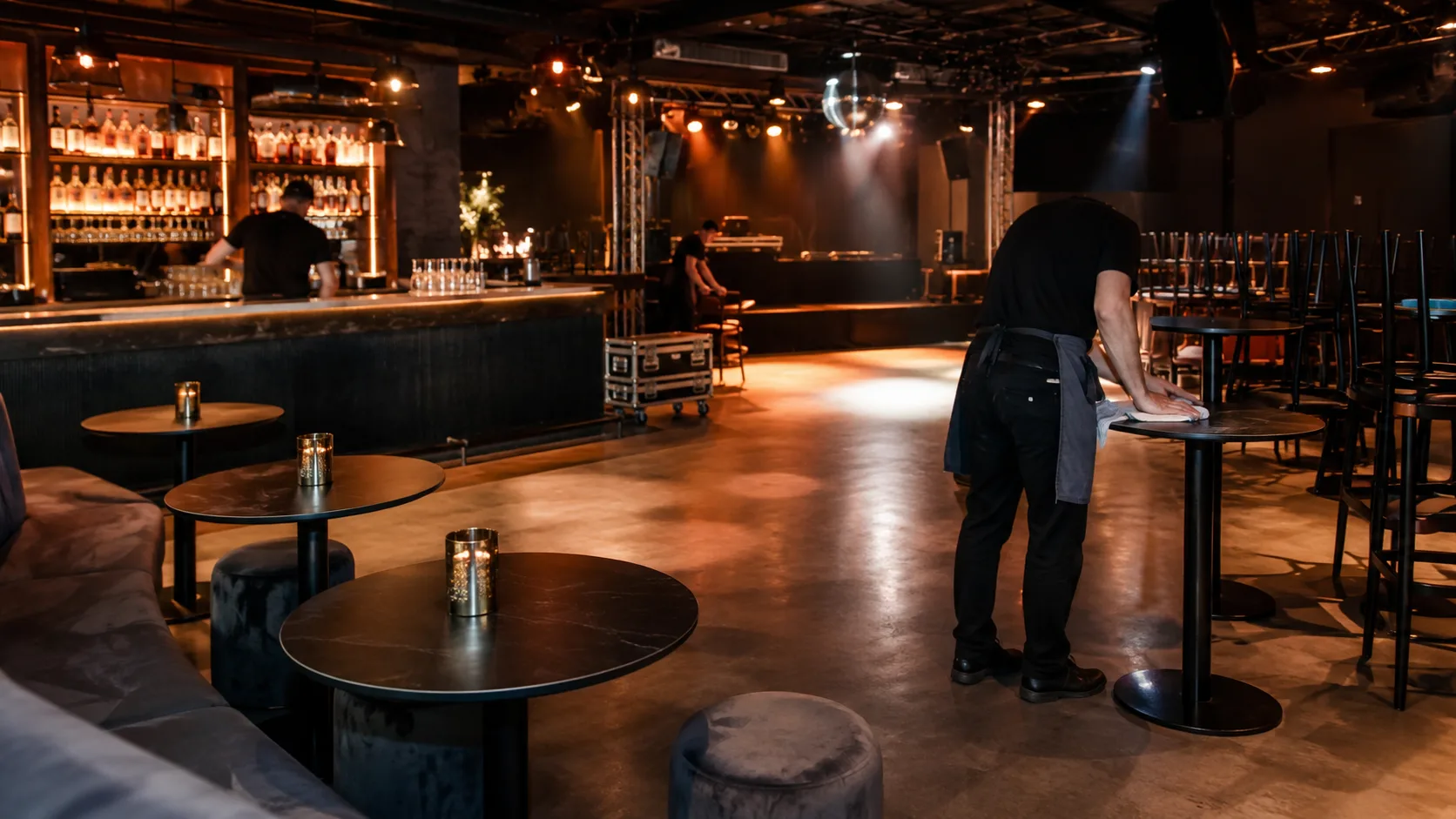 Nightclub bar furniture setup pre-service showing commercial bar stools and high-top tables