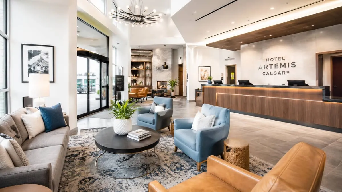 a boutique hotel lobby in Calgary featuring mixed seating arrangements with contract-grade armchairs, a wooden reception