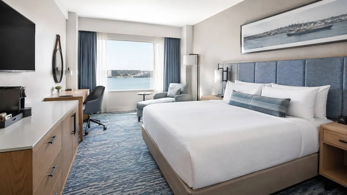 interior of a Halifax boutique hotel guestroom showing contract-grade headboard, case goods, and upholstered seating wit