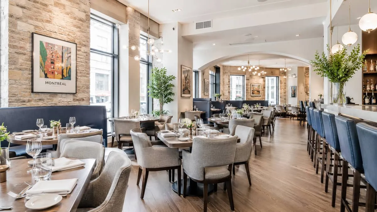 interior of a high-end Montreal restaurant with contract furniture in place, warm ambient lighting, exposed brick or sto