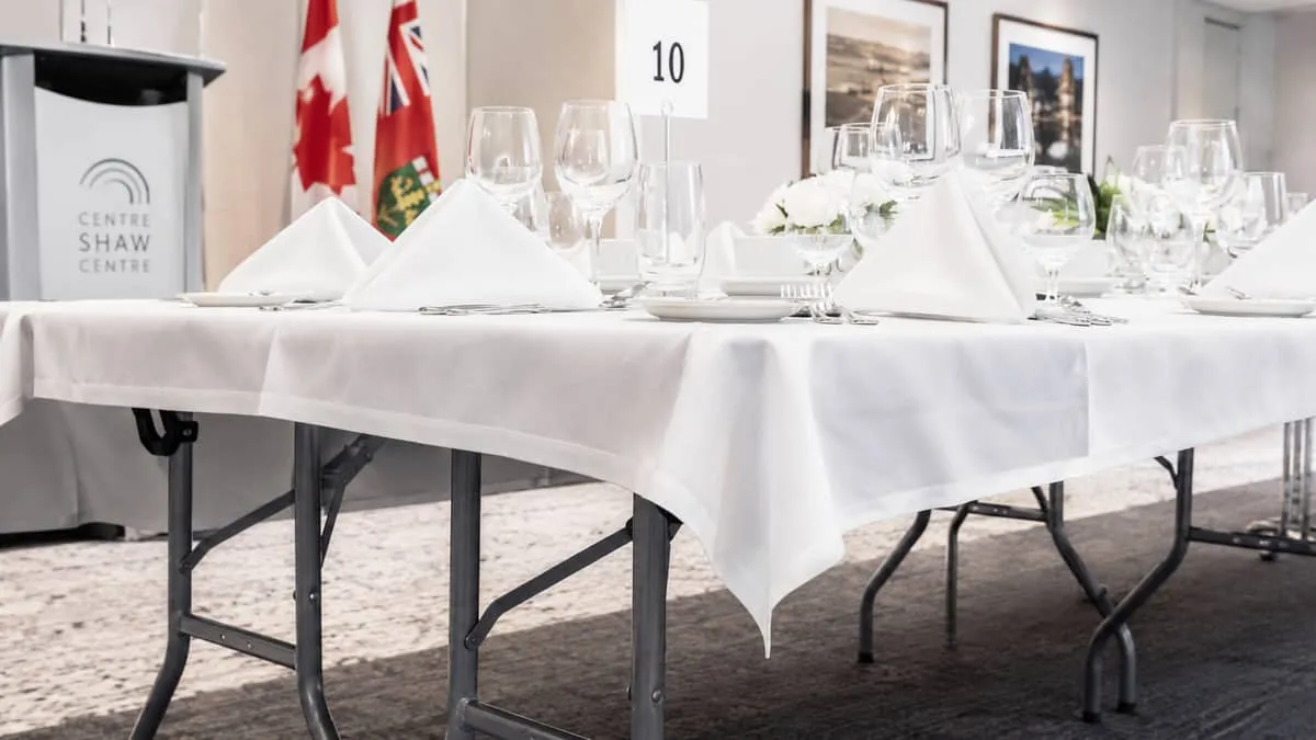 close-up of a commercial folding banquet table setup in an Ottawa convention space, showing the steel folding legs, line