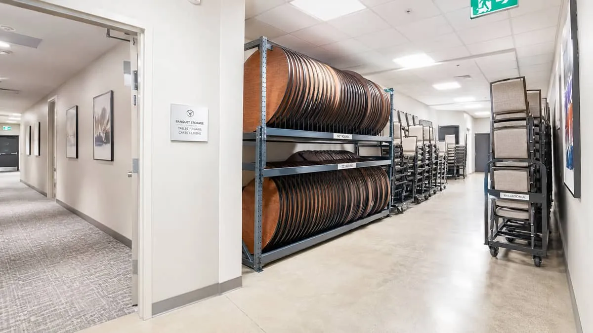 back-of-house storage area in an Ottawa hotel or event venue showing properly racked folding tables and stacked banquet 
