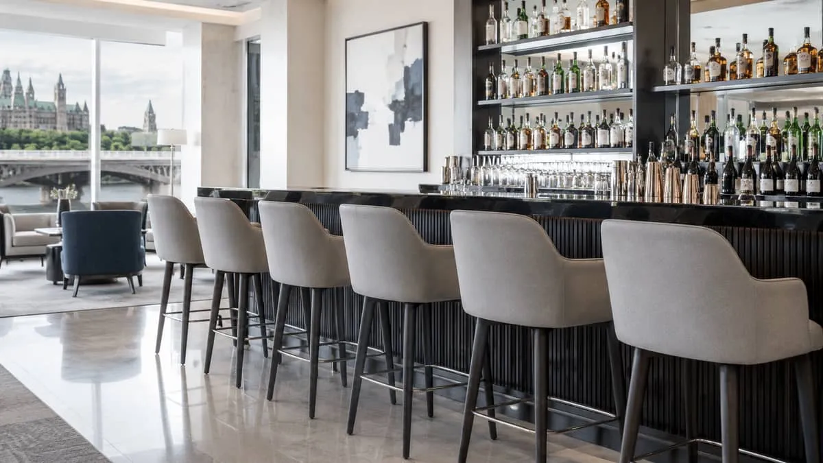 commercial barstools in a row along a polished bar counter in an upscale Ottawa hotel lounge, showing quality upholstery