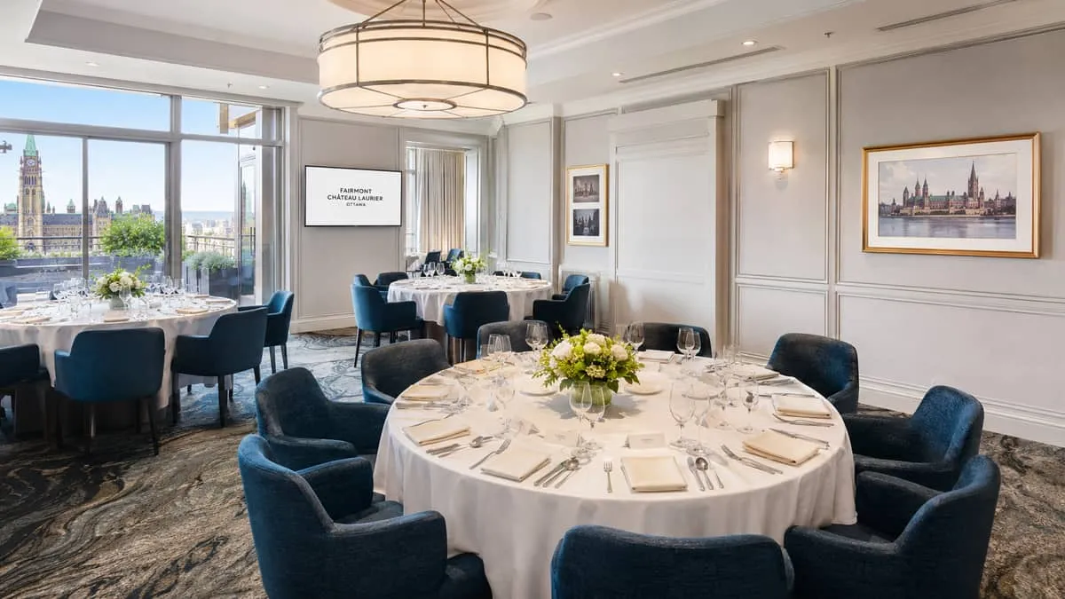 a well-appointed hotel guest room designed for business travelers, with a solid wood writing desk, upholstered task chai