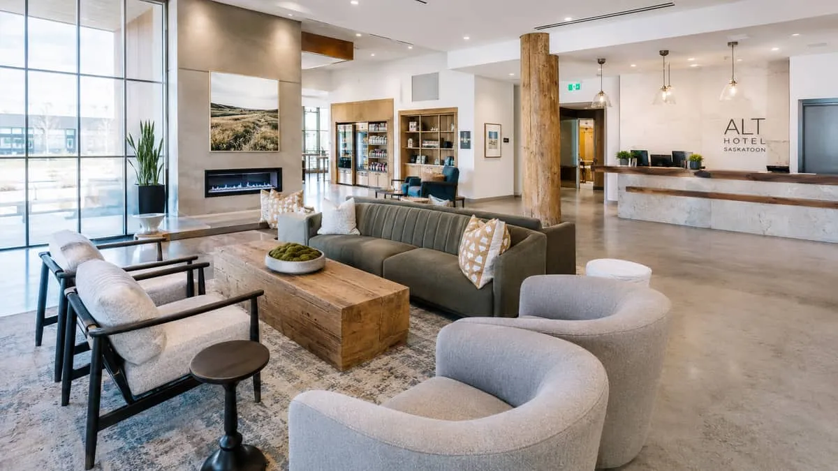 a boutique hotel lobby in a prairie city with a mix of custom upholstered seating, raw wood accent pieces, and warm ligh