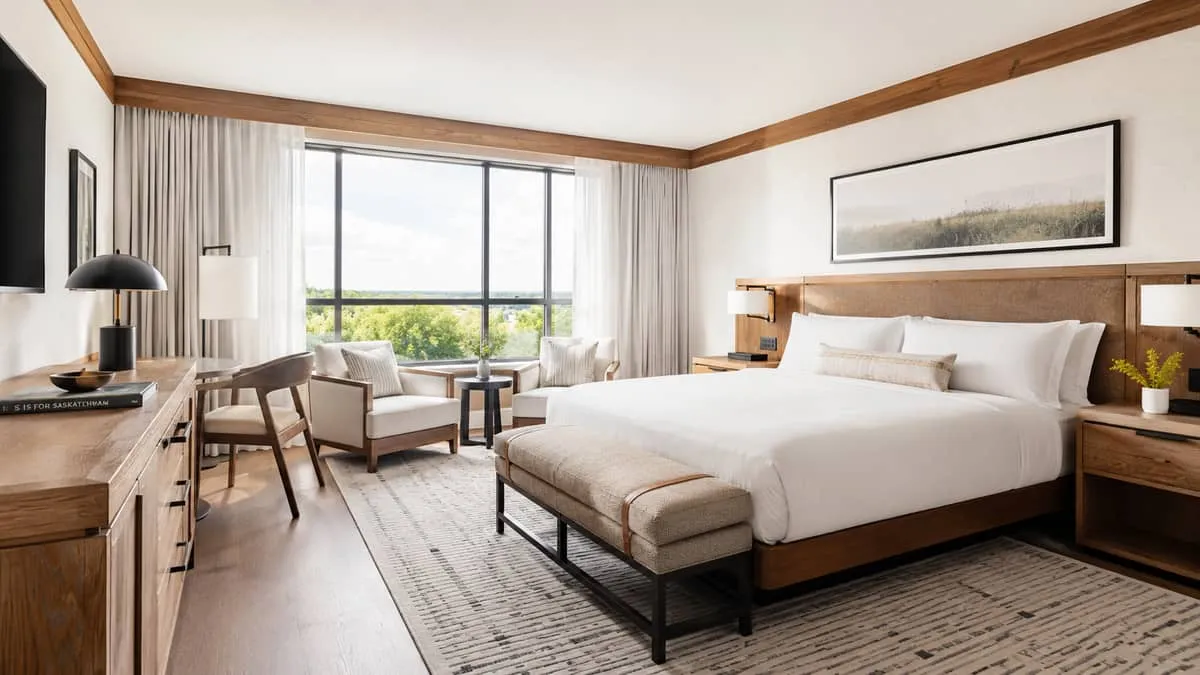 a boutique hotel guestroom featuring a mix of local wood accents and custom upholstered furniture with a cohesive neutra