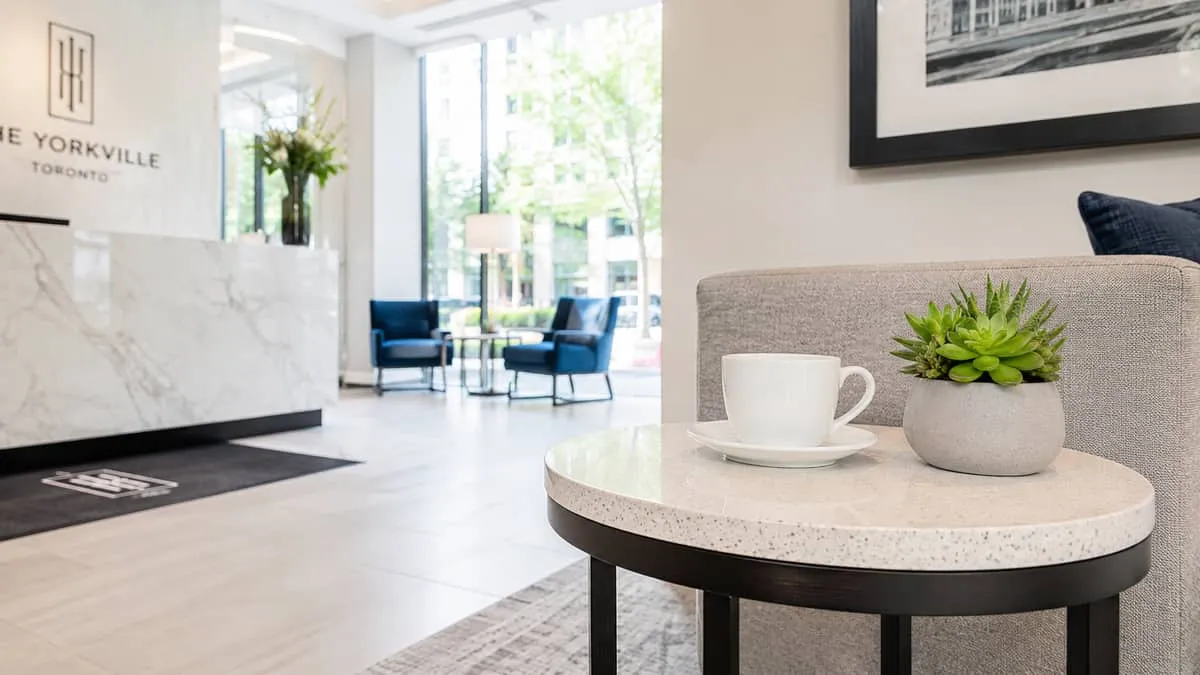 detail shot of a commercial side table in a hotel lobby setting showing durable surface material, clean lines, with a co