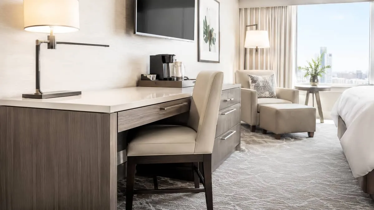 hotel guestroom desk and seating area showing durable contract-grade furniture with clean commercial construction, close