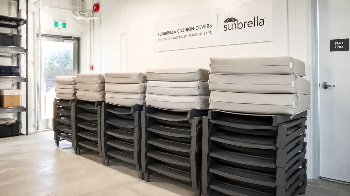 a row of Sunbrella cushion covers in a neutral tone on stacked commercial lounge chairs ready for storage, shown in a Va