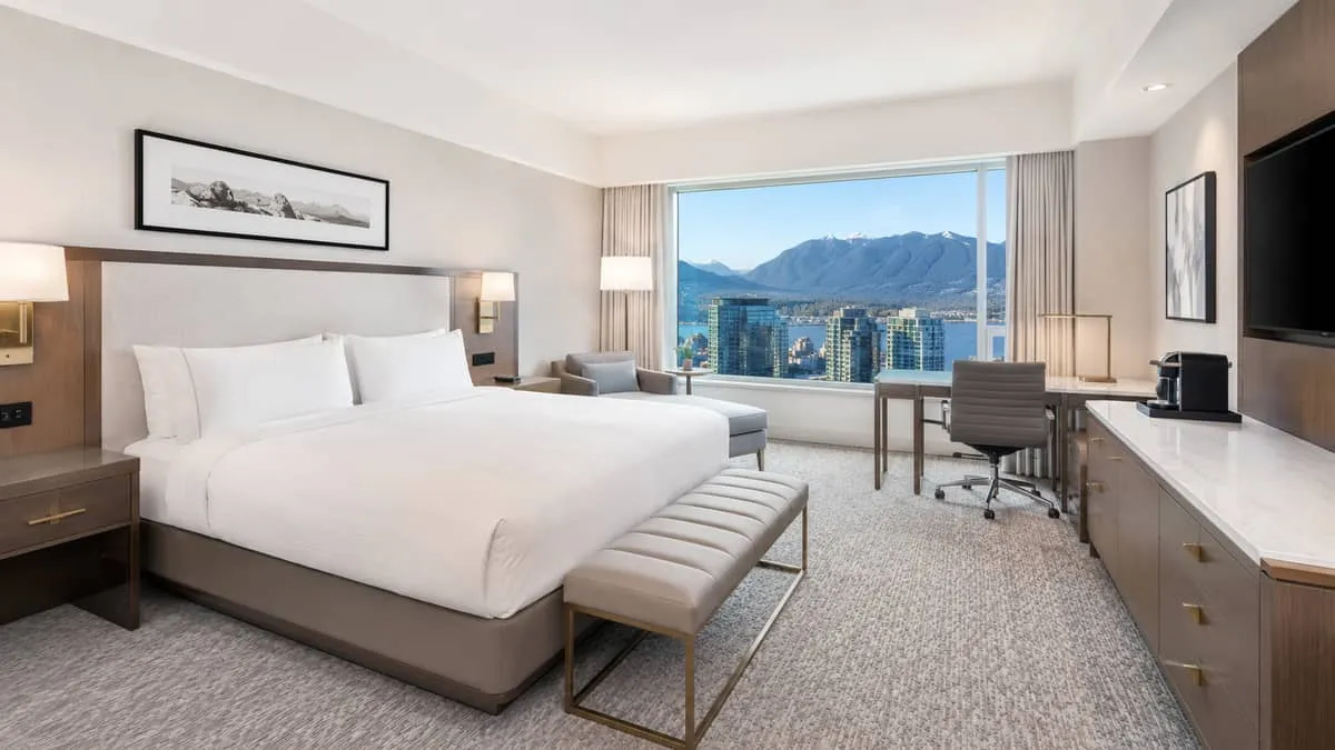 a Vancouver hotel room setup showing a fully specified guest room with contract-grade bed base, casegoods, upholstered b