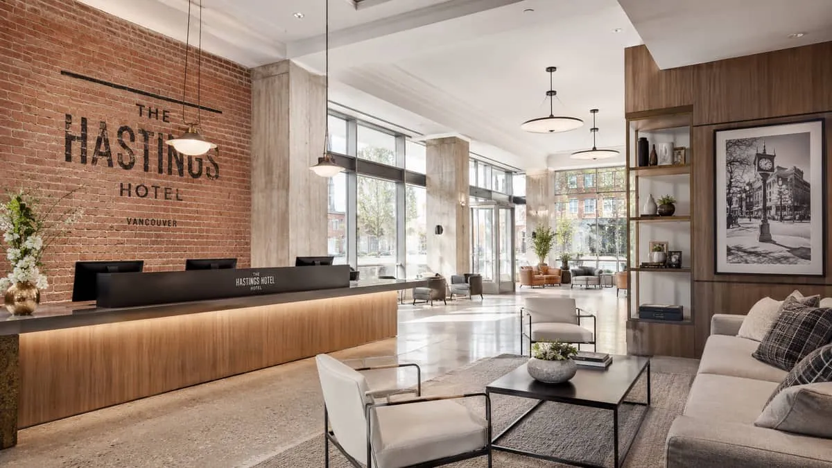 a Gastown boutique hotel lobby with new contract furniture installed, showing exposed brick walls paired with contempora