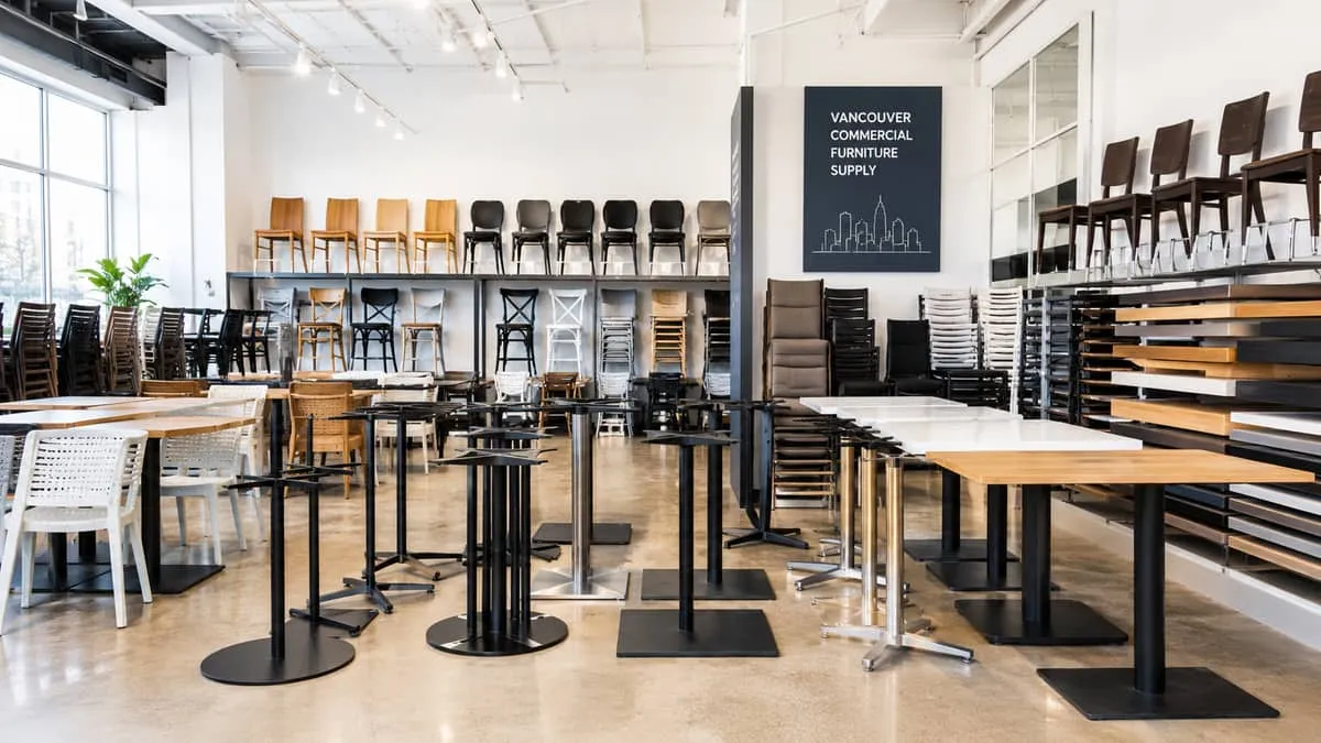 restaurant furniture Vancouver showroom or warehouse setting showing stacked dining chairs and table bases, representing