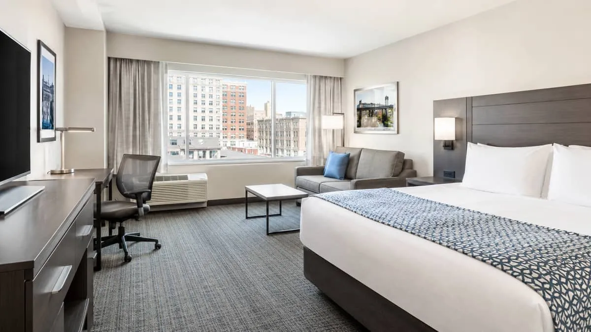 interior of a mid-market Winnipeg hotel room near the Exchange District, showing a clean, functional layout with upholst