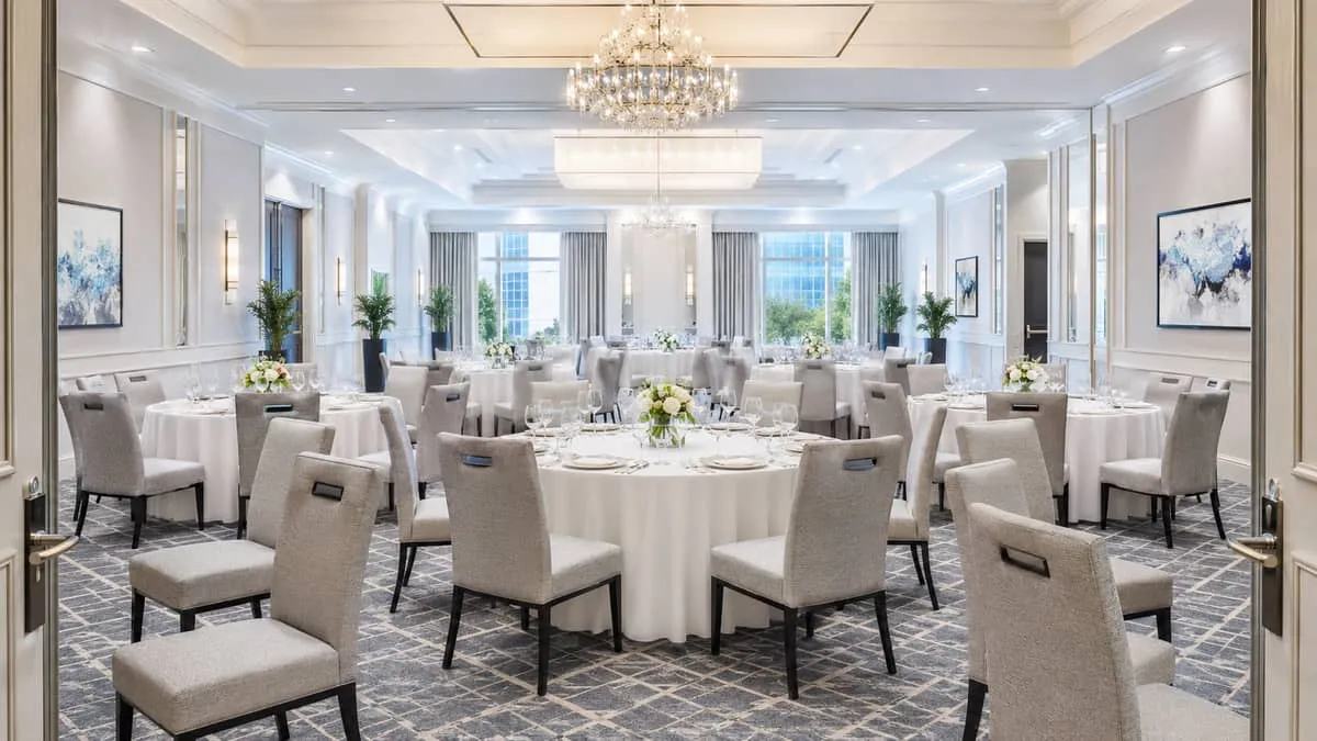 Completed Grand Rapids hotel ballroom event setup showing a uniform banquet chair program with round folding tables dressed for a corporate gala