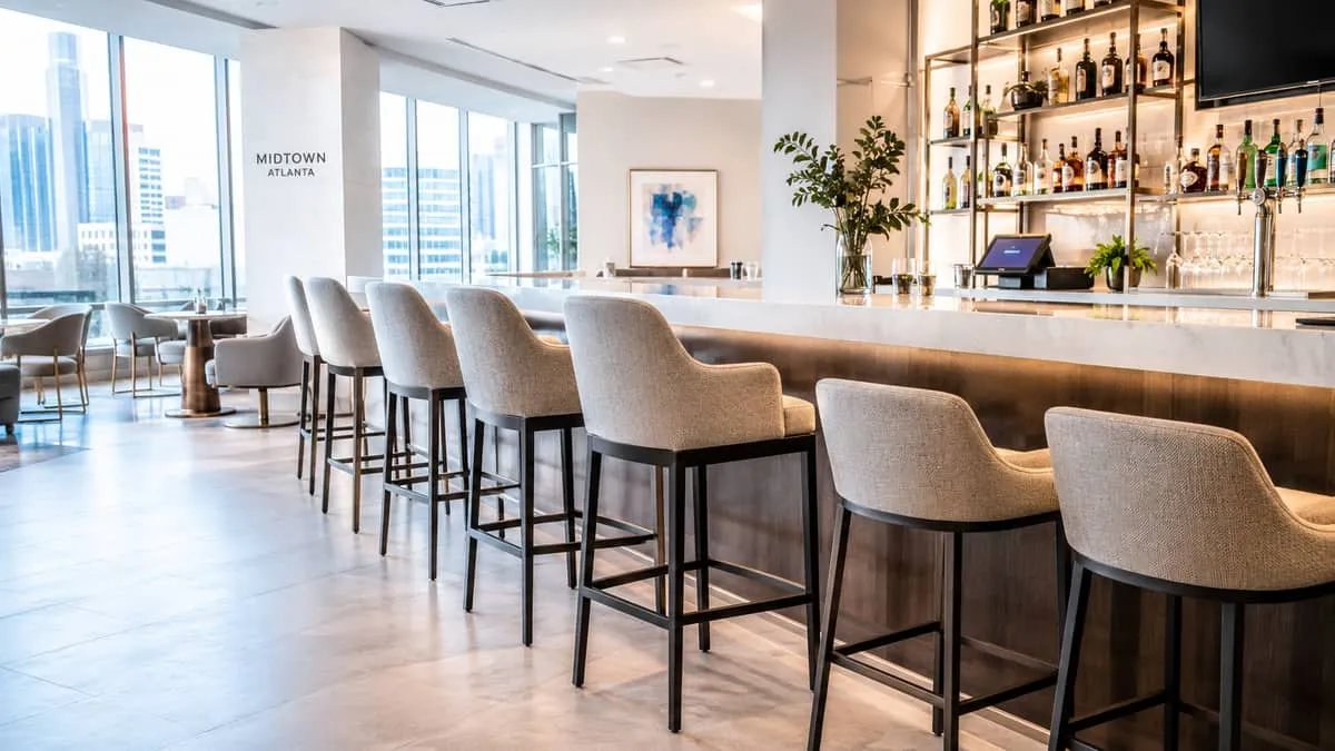 Midtown Atlanta cocktail bar lounge furniture showing curved seating silhouettes with warm-toned COM upholstery and mixed-material tables