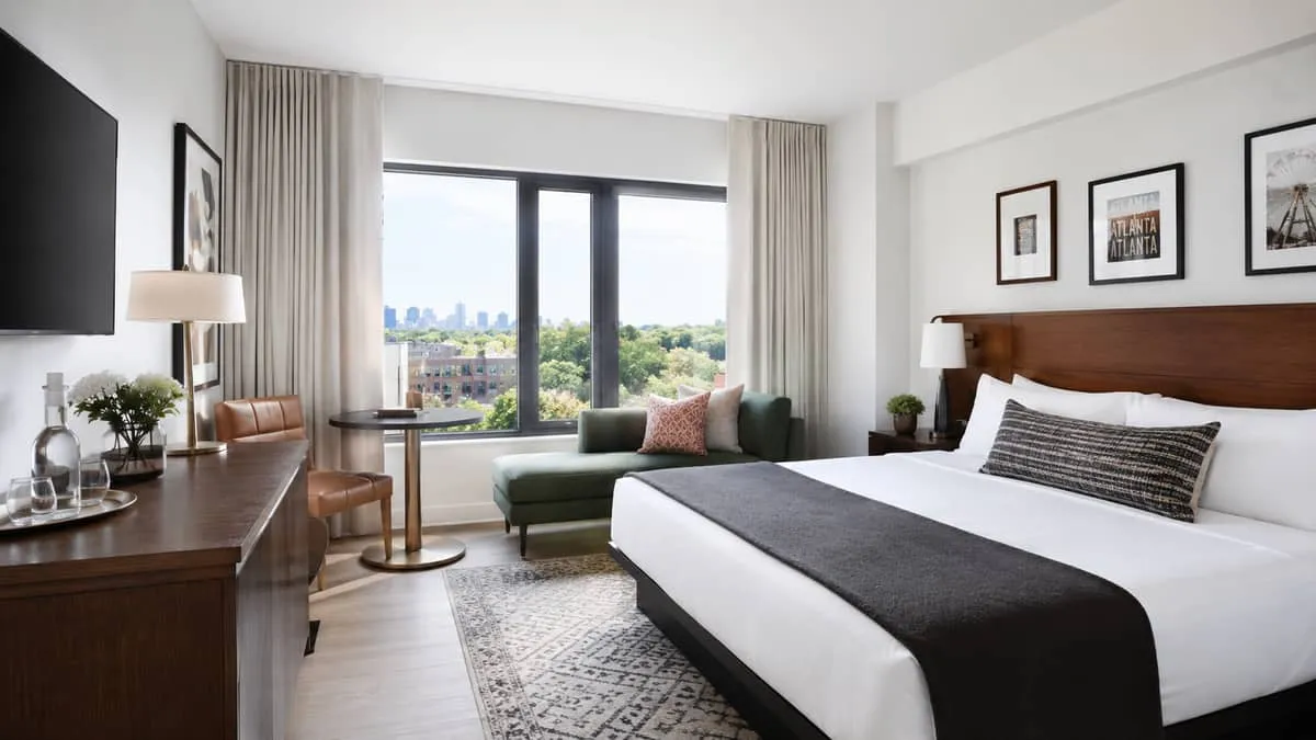 Grand Rapids boutique hotel guestroom showing a cohesive design palette with matching frame finishes and tonal upholstery program